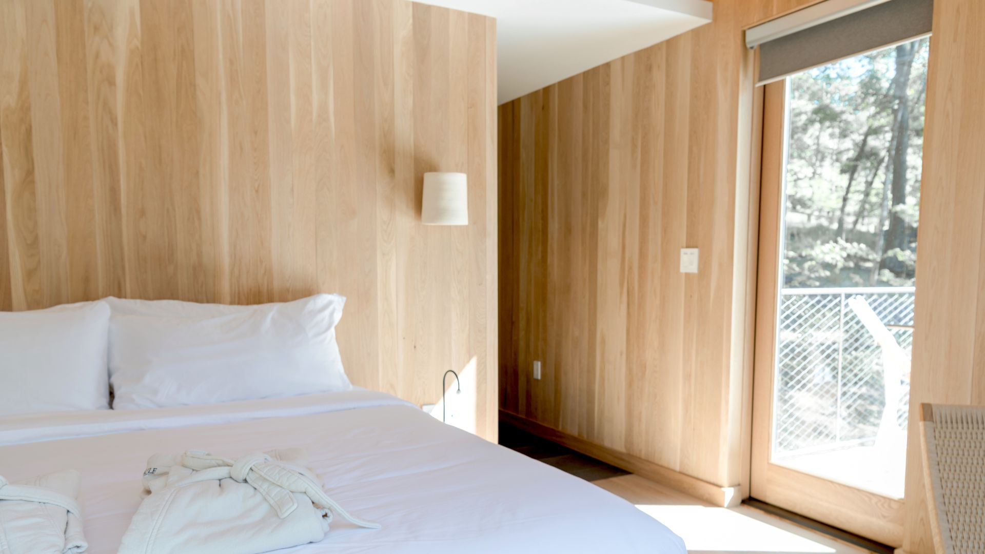 A bed with white sheets and pillows in a bedroom