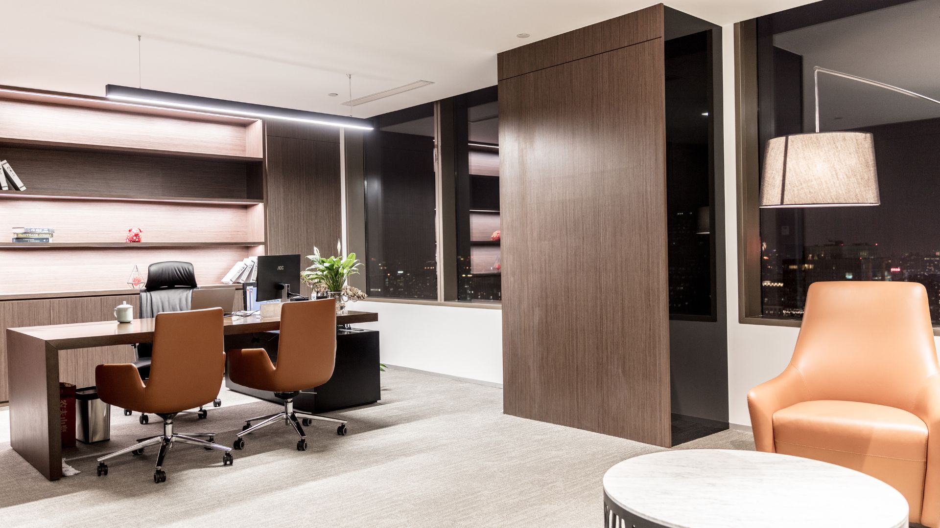 An office with a desk, chairs, and a book shelf